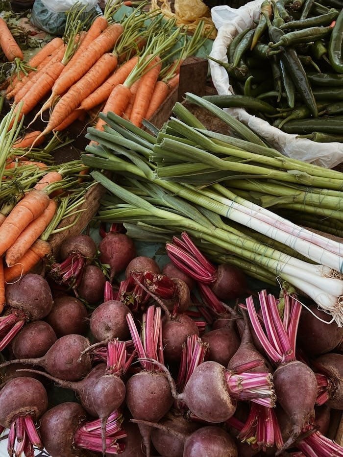 pexels-photo-14564807 A variety of fresh vegetables including carrots, beetroots, and leeks on a market stall.