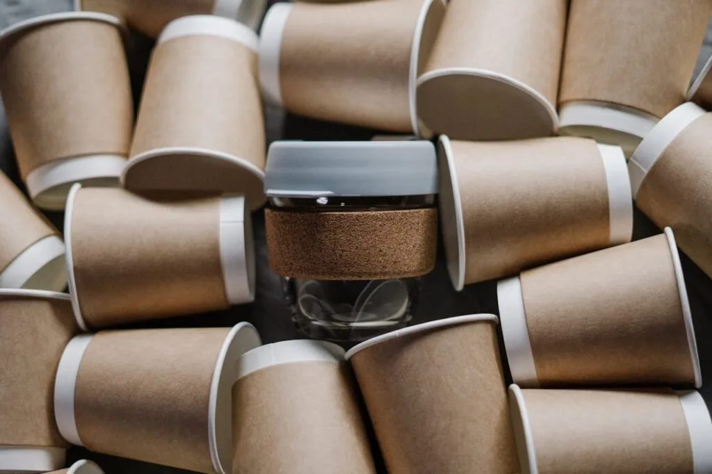 A reusable cup surrounded by paper cups emphasizes sustainability and zero waste.