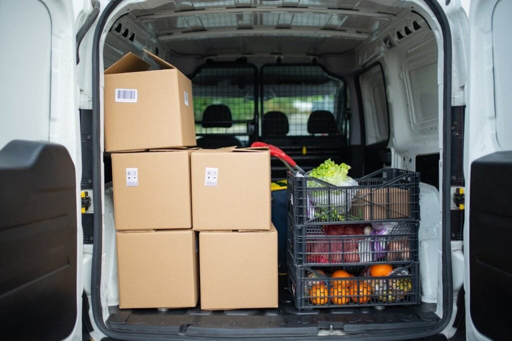 pexels-photo-7843985 Packed delivery van with boxes and fresh produce crates for efficient logistics.
